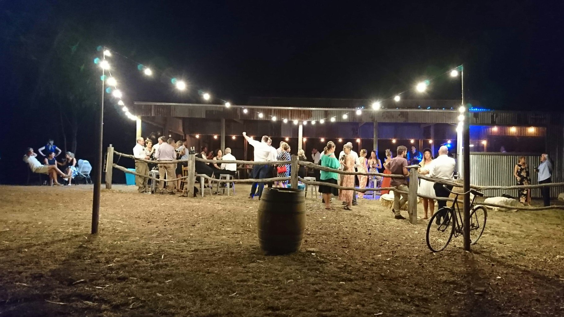 Wedding guests under fairy lights outside a country wedding.
